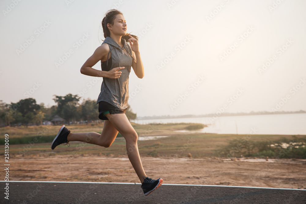 Young woman running in the nature. Healthy lifestyle and sport concepts.  Runner training in a urban area.The woman with runner on the street be  running for exercise. Stock Photo