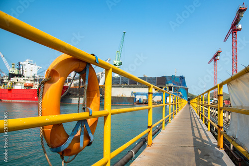 safety walkway in the port terninal job site, under securing by standard handrail and life buoy with steel checker plate floor anti-slippery, protection for all workers in the workplace photo