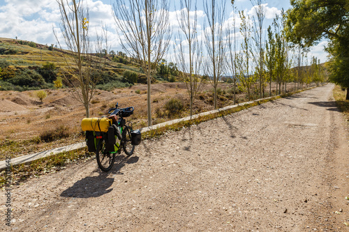 traveler's bike with bags stands on an empty gravel road
