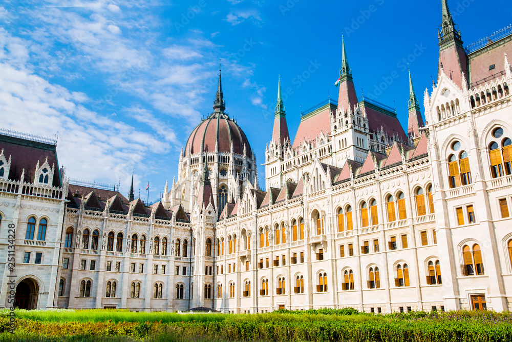 Facade of Hungarian Parliament in Budapest and courtyard. Bright summer day. Bright blue sky in summer. 