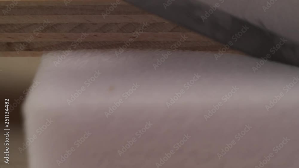 A close-up of knife cutting off a piece of poly foam for seats and cushions A close-up of knife cutting off a piece of poly foam for seats and cushions