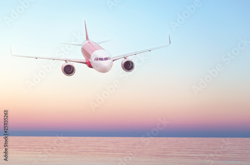 Plane flying in the sky, summer travel flight, airplane over water, flight over skyline. Sunset over the sea. Empty place for text, copy space..