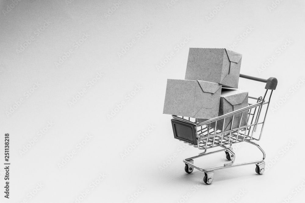 Shopping cart and box  on black and white background, business and shopping concept. Selective focus