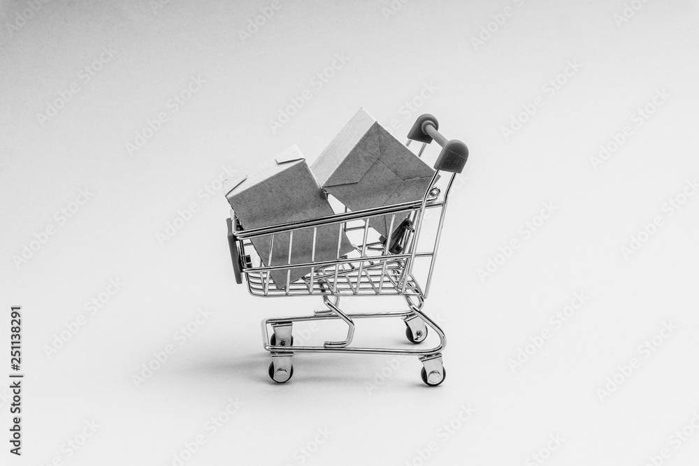 Shopping cart and box on black and white background, business and shopping concept. Selective focus Shopping cart and box on black and white background, business and shopping concept. Selective focus