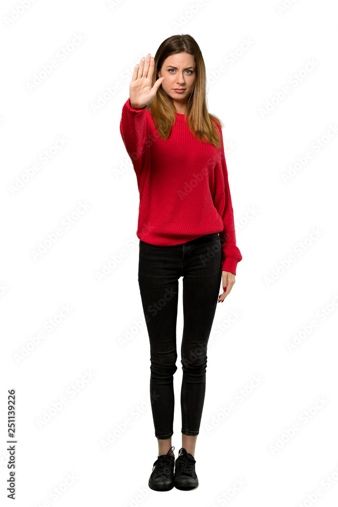A full-length shot of a Young woman with red sweater making stop gesture denying a situation that thinks wrong over isolated white background A full-length shot of a Young woman with red sweater making stop gesture denying a situation that thinks wrong over isolated white background