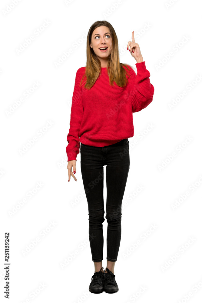 A full-length shot of a Young woman with red sweater intending to realizes the solution while lifting a finger up over isolated white background A full-length shot of a Young woman with red sweater intending to realizes the solution while lifting a finger up over isolated white background