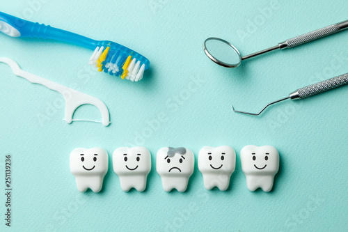 Tableau sur toile Healthy white teeth are smiling and tooth with caries is sad on green mint background