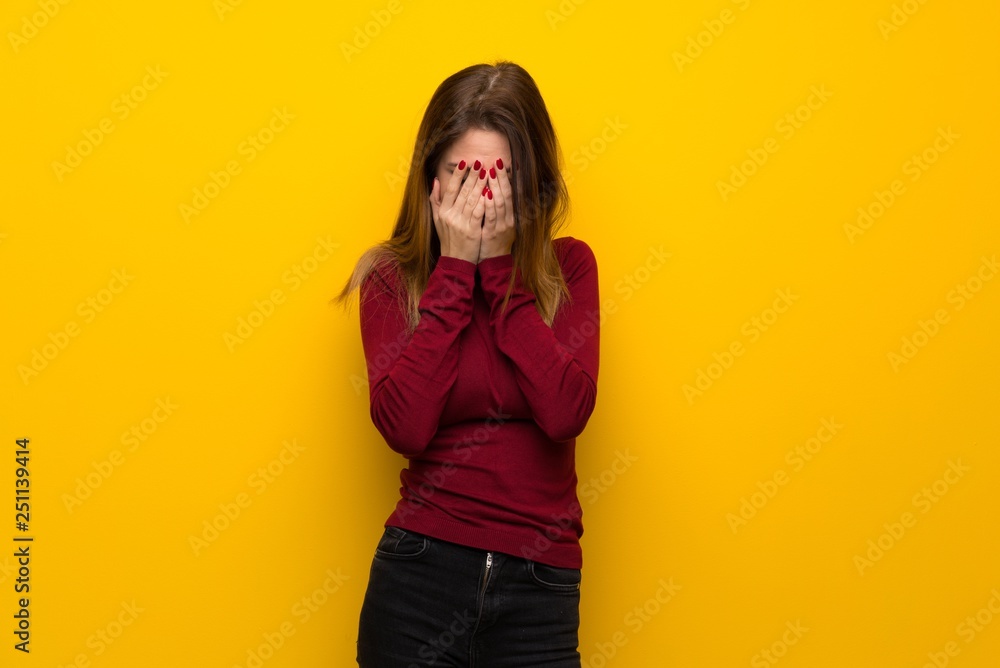 Woman with turtleneck over yellow wall with tired and sick expression Woman with turtleneck over yellow wall with tired and sick expression