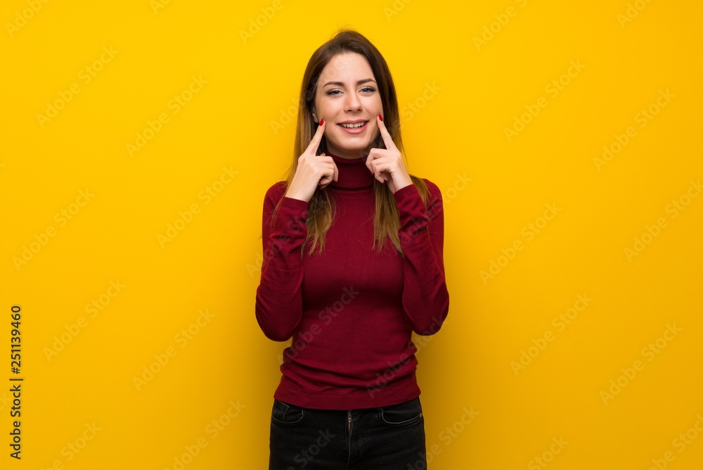 Woman with turtleneck over yellow wall smiling with a happy and pleasant expression Woman with turtleneck over yellow wall smiling with a happy and pleasant expression