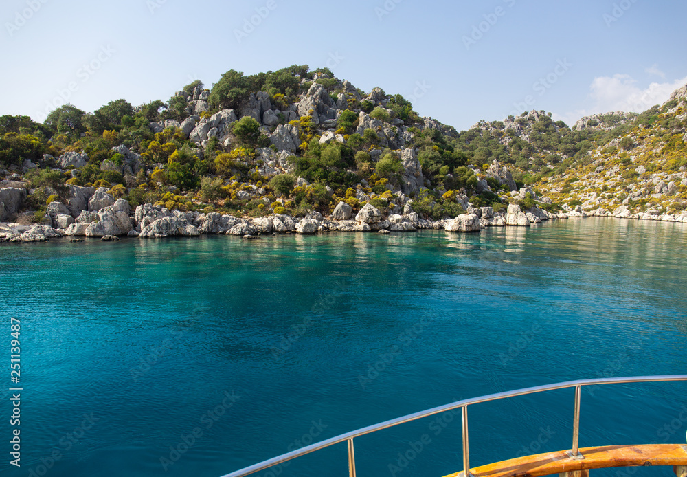 Powerboat. View from the boat. Mediterranean sea overlooking the mountains. Aerial top view of sea waves hitting rocks on the beach with turquoise sea water.