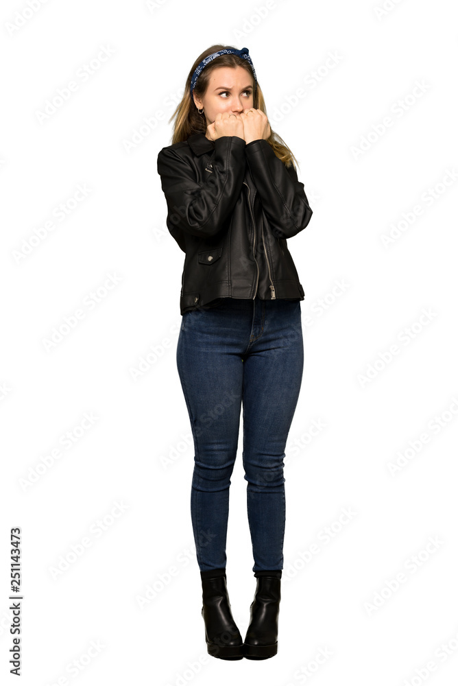 A full-length shot of a Teenager girl with leather jacket is a little bit nervous and scared putting hands to mouth on isolated white background A full-length shot of a Teenager girl with leather jacket is a little bit nervous and scared putting hands to mouth on isolated white background