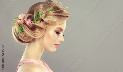 Beautiful model girl  with elegant hairstyle and rose flowers in a plait . Woman with fashion  spring hair.