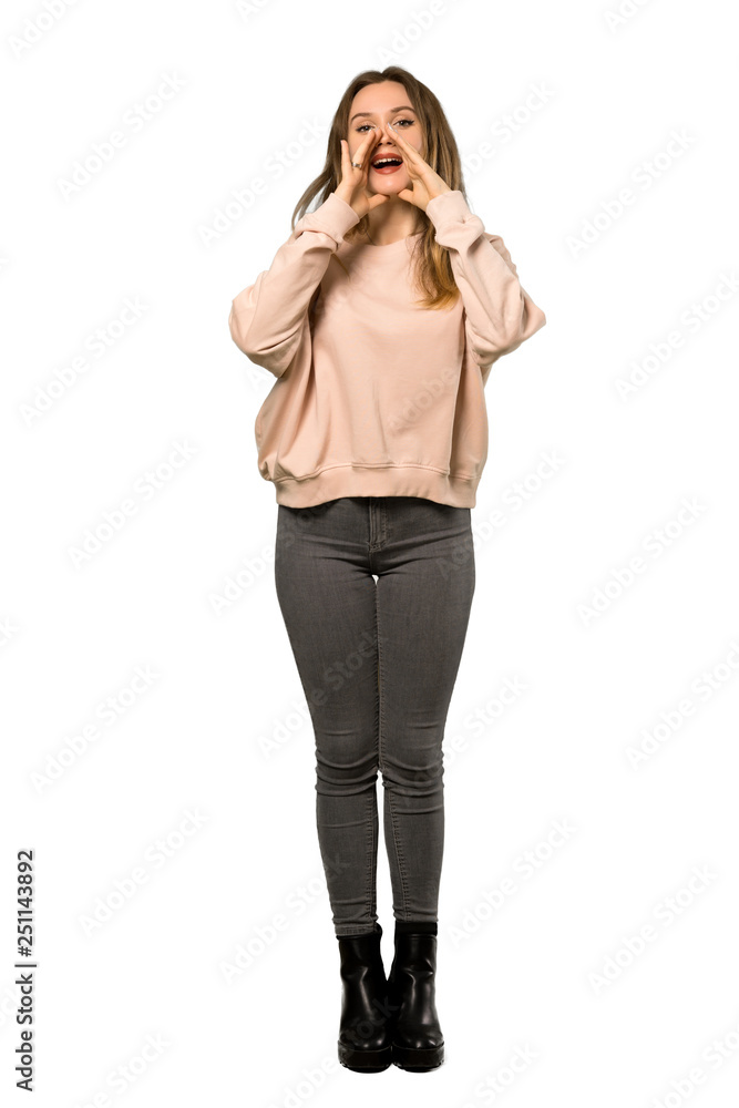 A full-length shot of a Teenager girl with pink sweater shouting and announcing something over isolated white background A full-length shot of a Teenager girl with pink sweater shouting and announcing something over isolated white background