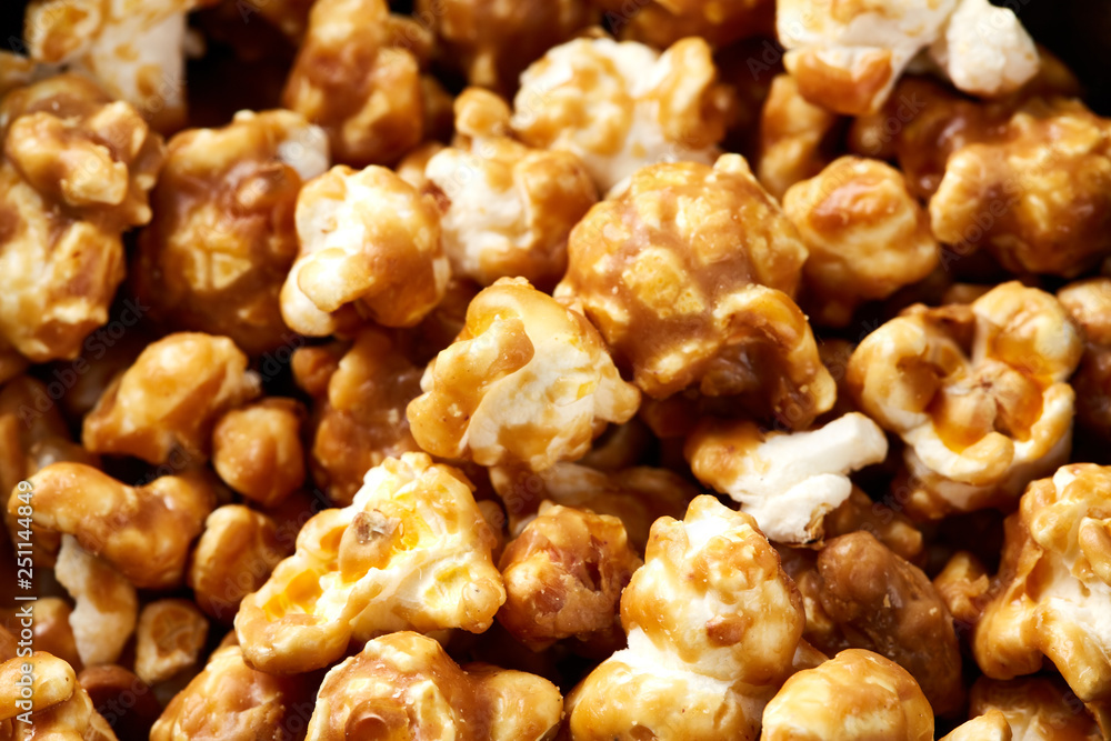caramel pop corn background. Golden caramel popcorn close up. Background of popcorn. Snacks and food for a movie caramel pop corn background. Golden caramel popcorn close up. Background of popcorn. Snacks and food for a movie