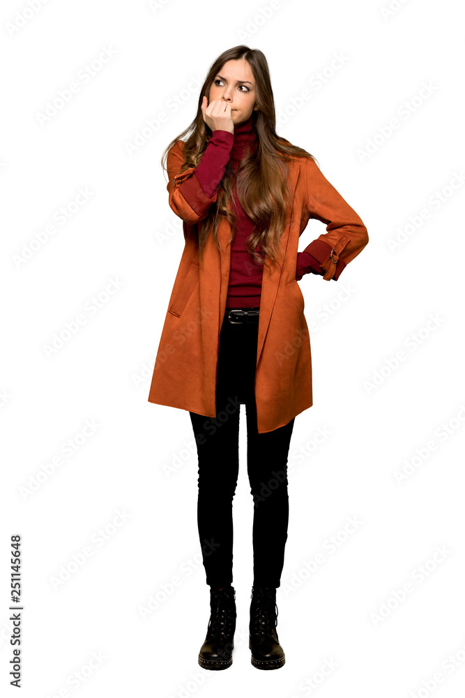 Full-length shot of Young woman with coat having doubts on isolated white background Full-length shot of Young woman with coat having doubts on isolated white background