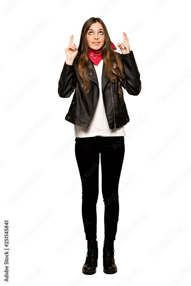 Full-length shot of Young woman with leather jacket with fingers crossing and wishing the best on isolated white background Full-length shot of Young woman with leather jacket with fingers crossing and wishing the best on isolated white background