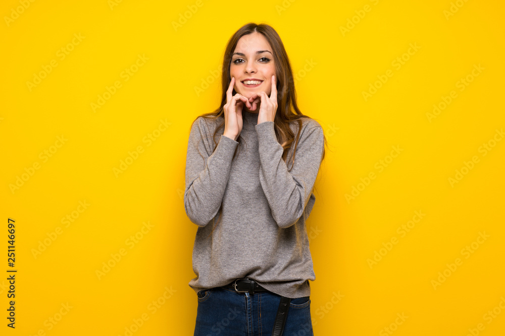 Young woman over yellow wall smiling with a happy and pleasant expression Young woman over yellow wall smiling with a happy and pleasant expression