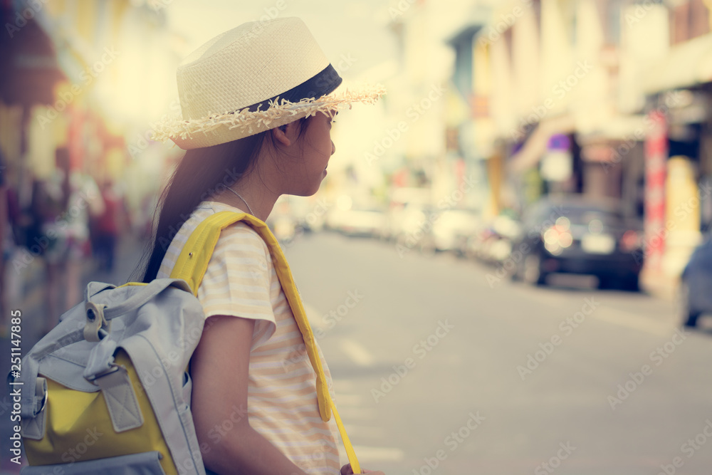 Young girl Traveler with backpack standing in old town, Phuket, Thailand.