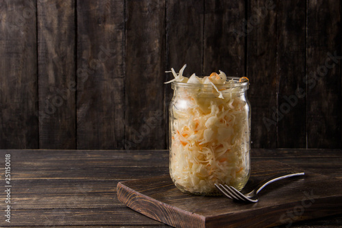 Obraz na płótnie Sauerkraut with carrots in a jar on a dark background