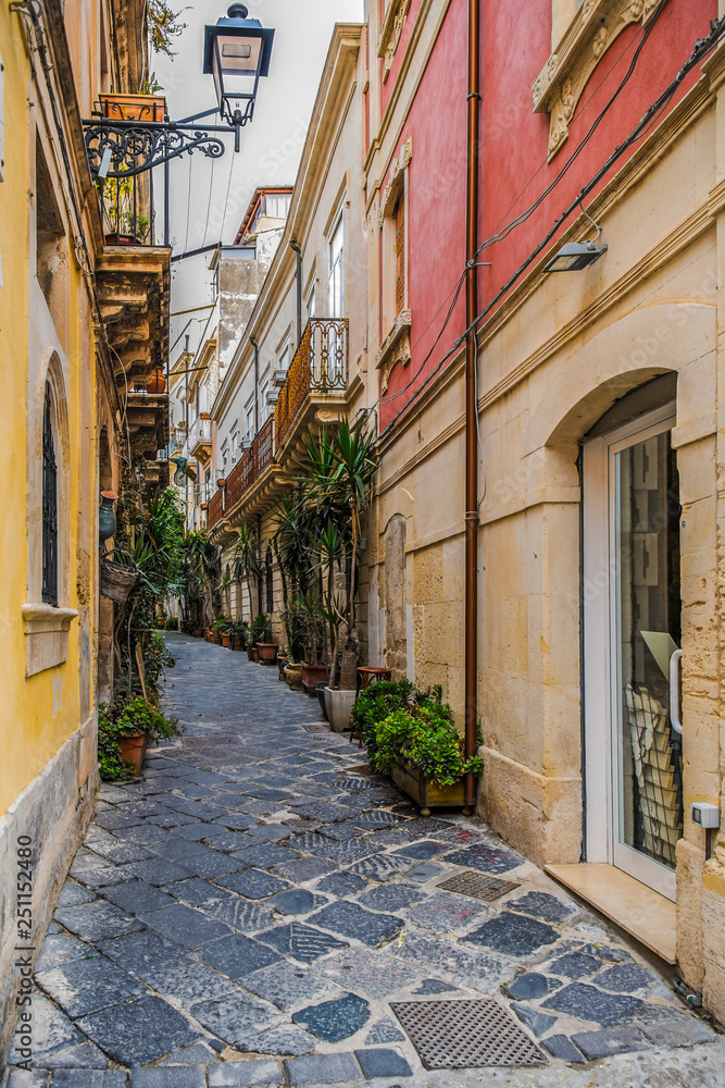 Obraz premium Narrow italian street in the ancient Ortygia island, Syracuse, Sicily, Italy