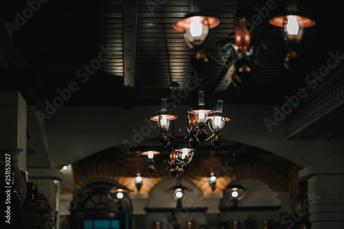 The old black chandelier lights up in a restaurant.