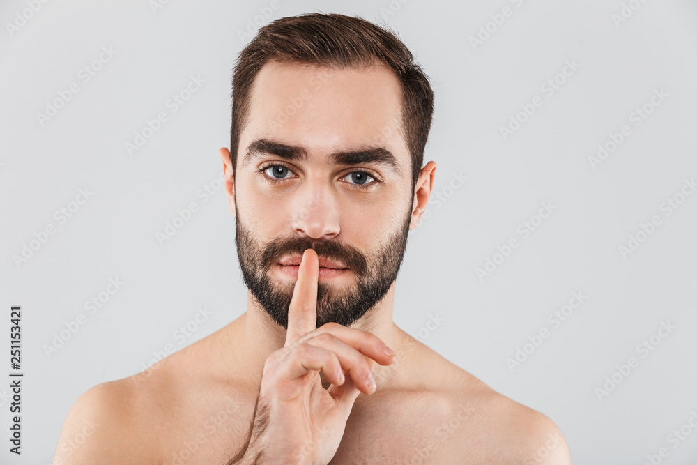 Close up of a young handsome bearded shirtless man