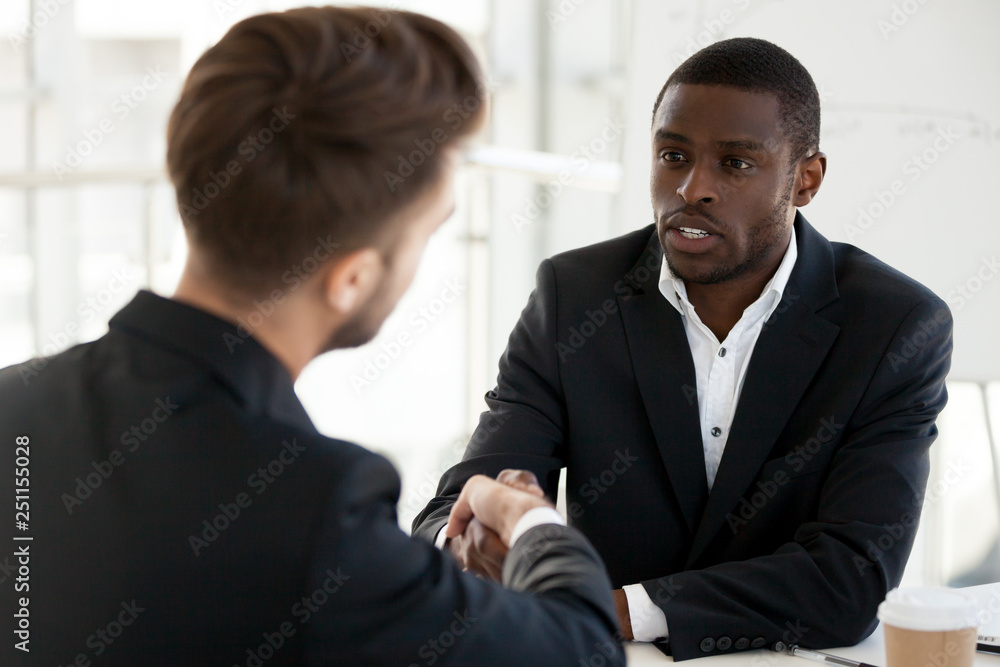 Diverse businessmen shaking hands greeting each other Diverse businessmen shaking hands greeting each other