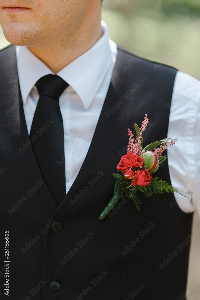 Young man in costume with a bouquet in his chest. Young man in costume with a bouquet in his chest.