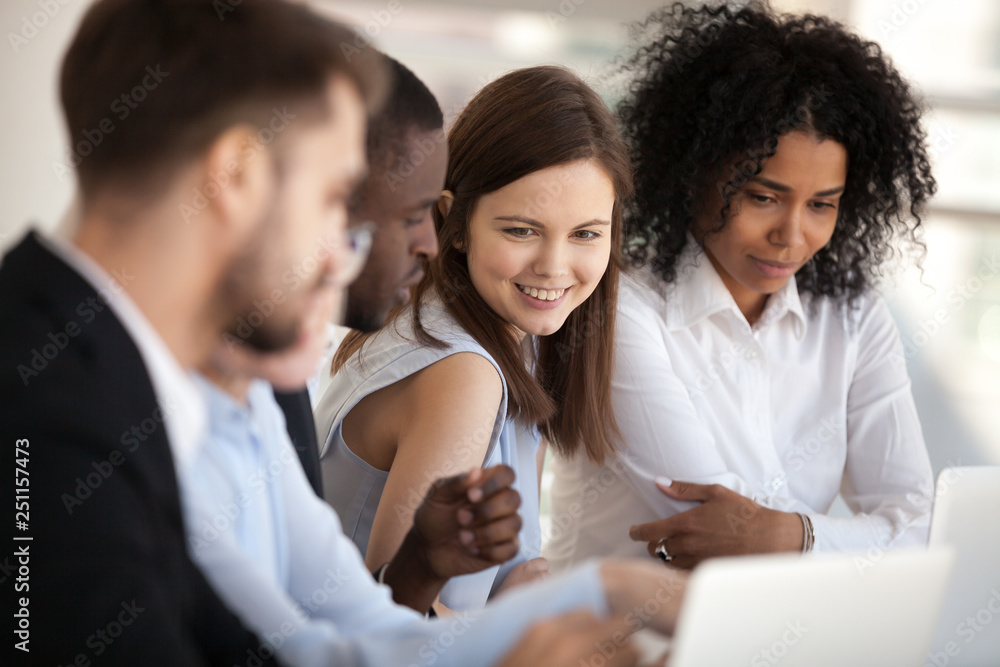 Positive diverse coworkers businesspeople sitting during briefing Positive diverse coworkers businesspeople sitting during briefing