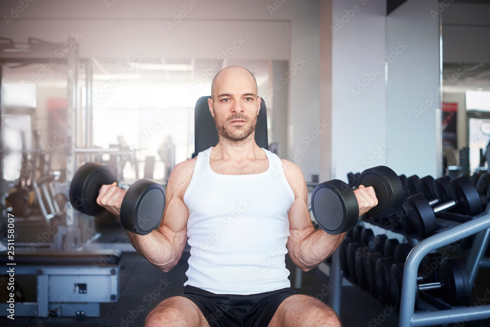 Man using dumbbell while workout in the gym Man using dumbbell while workout in the gym