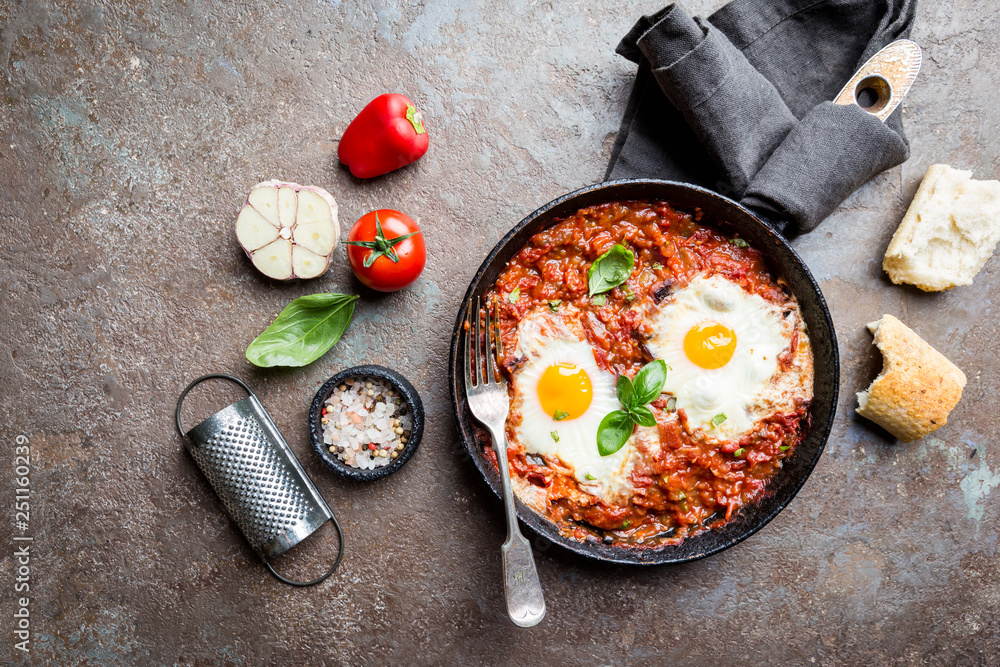 Shakshuka, Fried Eggs in Tomato Sauce in iron frying pan. Typical