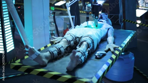 dead humanoid alien lying on the table