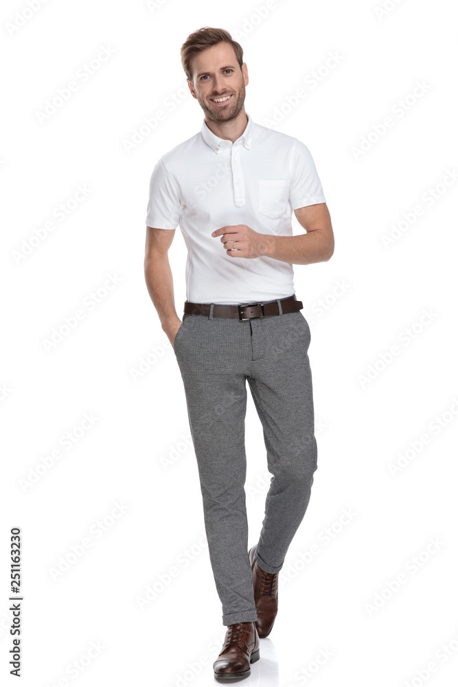 relaxed young casual man walks forward with hand in pocket relaxed young casual man walks forward with hand in pocket