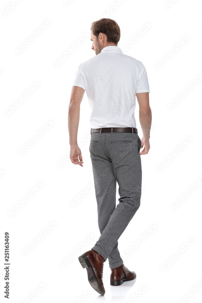 back view of a walking casual man looking to side back view of a walking casual man looking to side