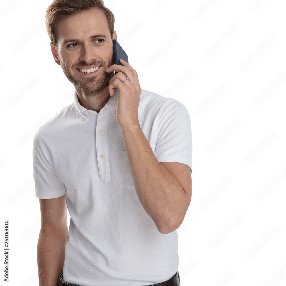 smiling casual man talks on the phone and looks to side smiling casual man talks on the phone and looks to side