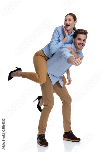 excited woman looking surprisd while being carried by young man
