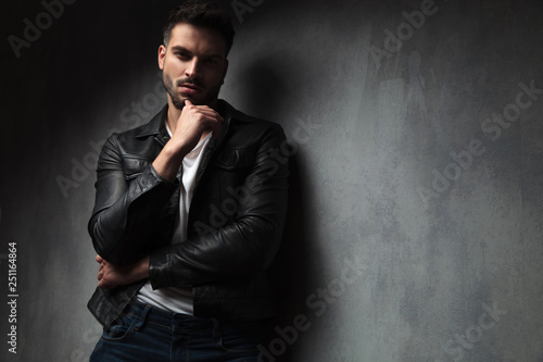 attractive man in leather jacket with finger on his chin