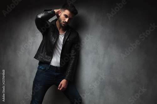 fashion man in leather jacket posing with hand behind head