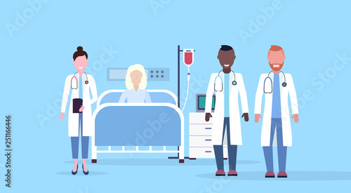 mix race doctors team visiting patient senior woman lying bed intensive therapy ward healthcare concept hospital room blue background modern medical clinic horizontal