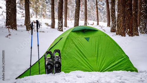 bats and snowshoes in front of tents in winter camp 