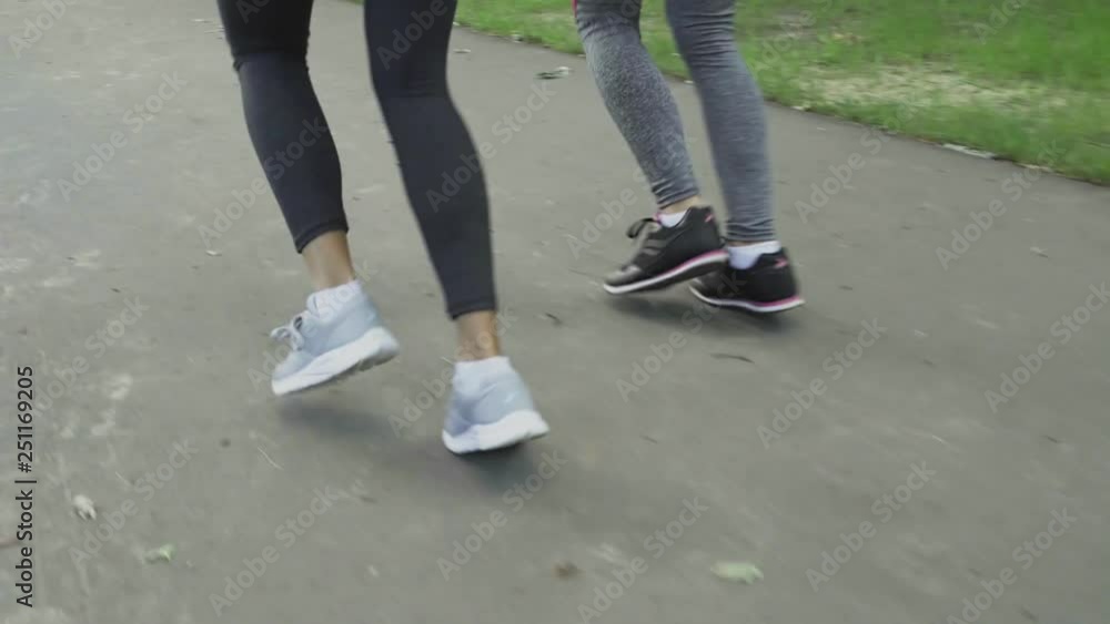 Close Up Of Athletic Female Legs Running At Park Road Close Up Of Athletic Female Legs Running At Park Road