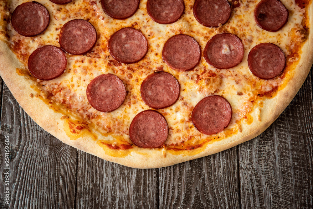 Pizza pepperoni on wooden table close up Pizza pepperoni on wooden table close up
