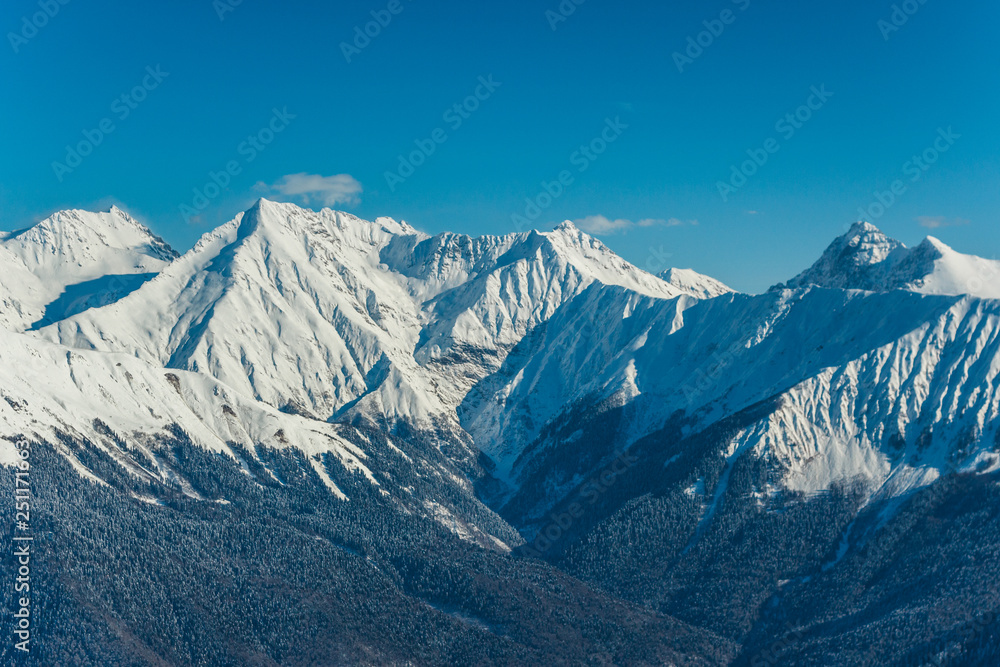 Beautiful landscape view of mountains covered on snow with dark and brown hills in the foreground