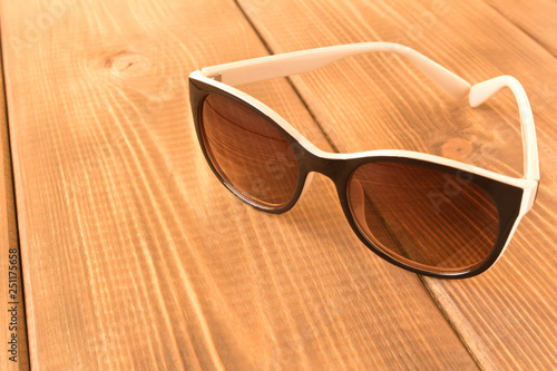 Sunglasses on wooden table. The concept of summer.
