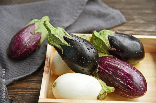 3 colorful mixed of Eggplant (Solanum melongena) or aubergine with water drop in wooden box on wooden background.