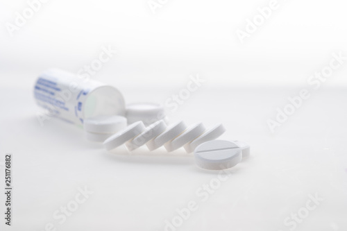 Antipyretic tablets, painkillers scattered on the table on a white background