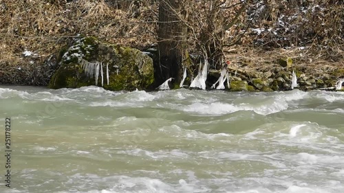 Ice on branches and the river flow photo