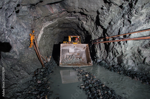 Underground gold ore mine shaft tunnel gallery passage with load, haul, dump machine LHD photo