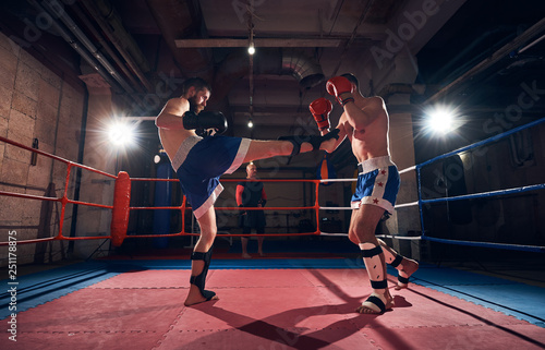 Two handsome men boxers exercising kickboxing in the ring at the sport club © anatoliy_gleb