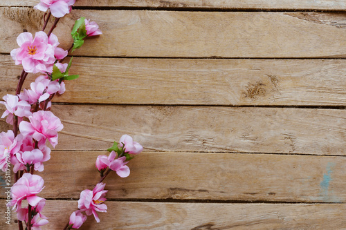 Cherry blossom and Artificial flowers on vintage wooden background with copy space.